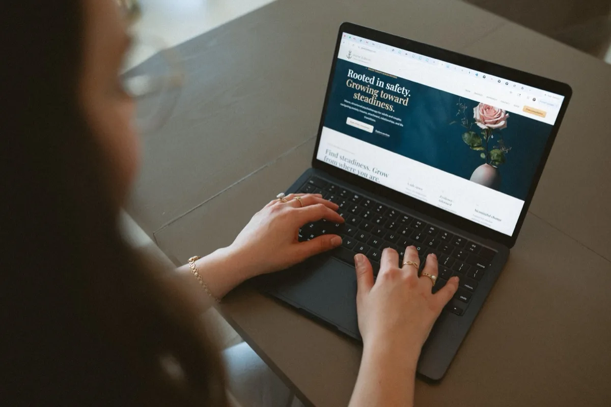 The Anchor & Bloom website on a laptop with flowers alongside