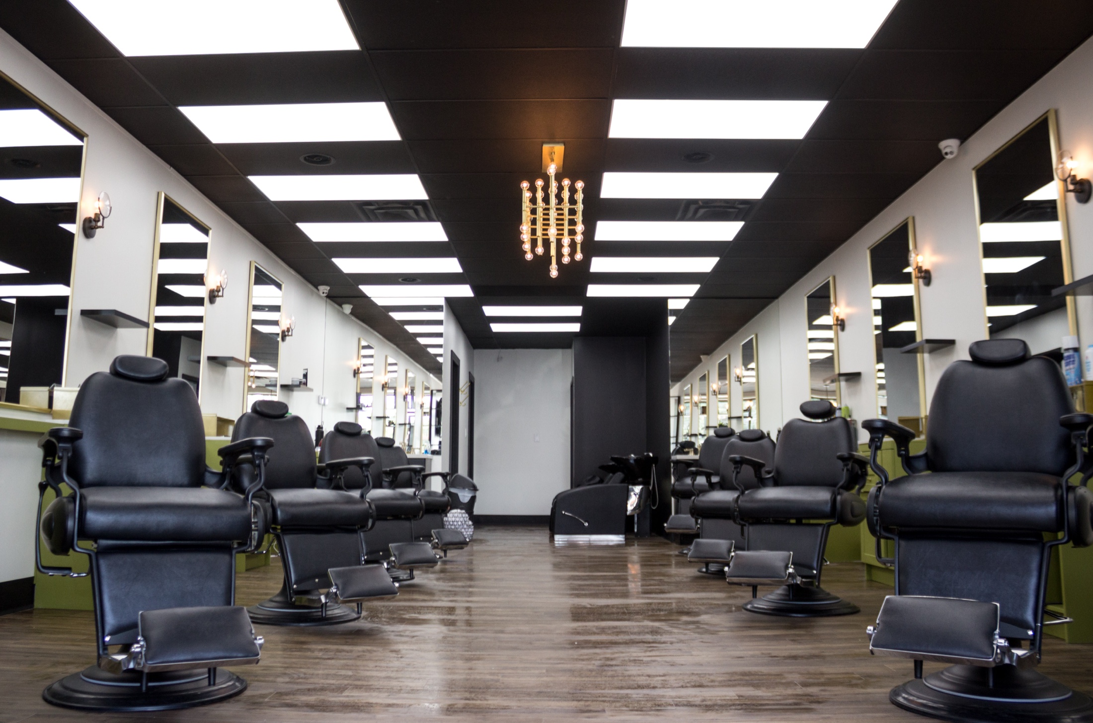 Chair barbershop interior, Toronto, eight chairs symmetric with gold chandelier