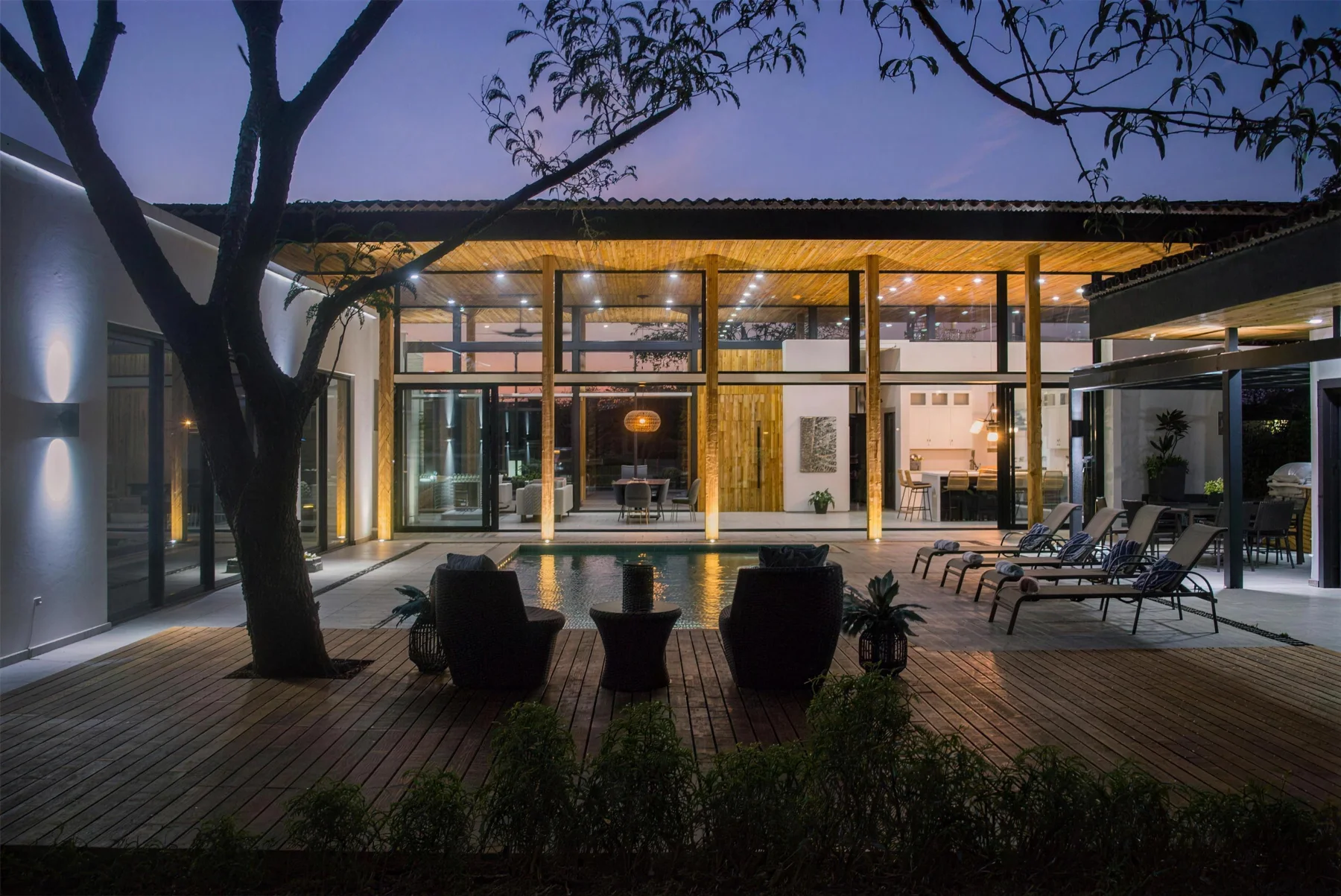 Las Brisas 30 at dusk, with warm interiors opening onto a pool courtyard