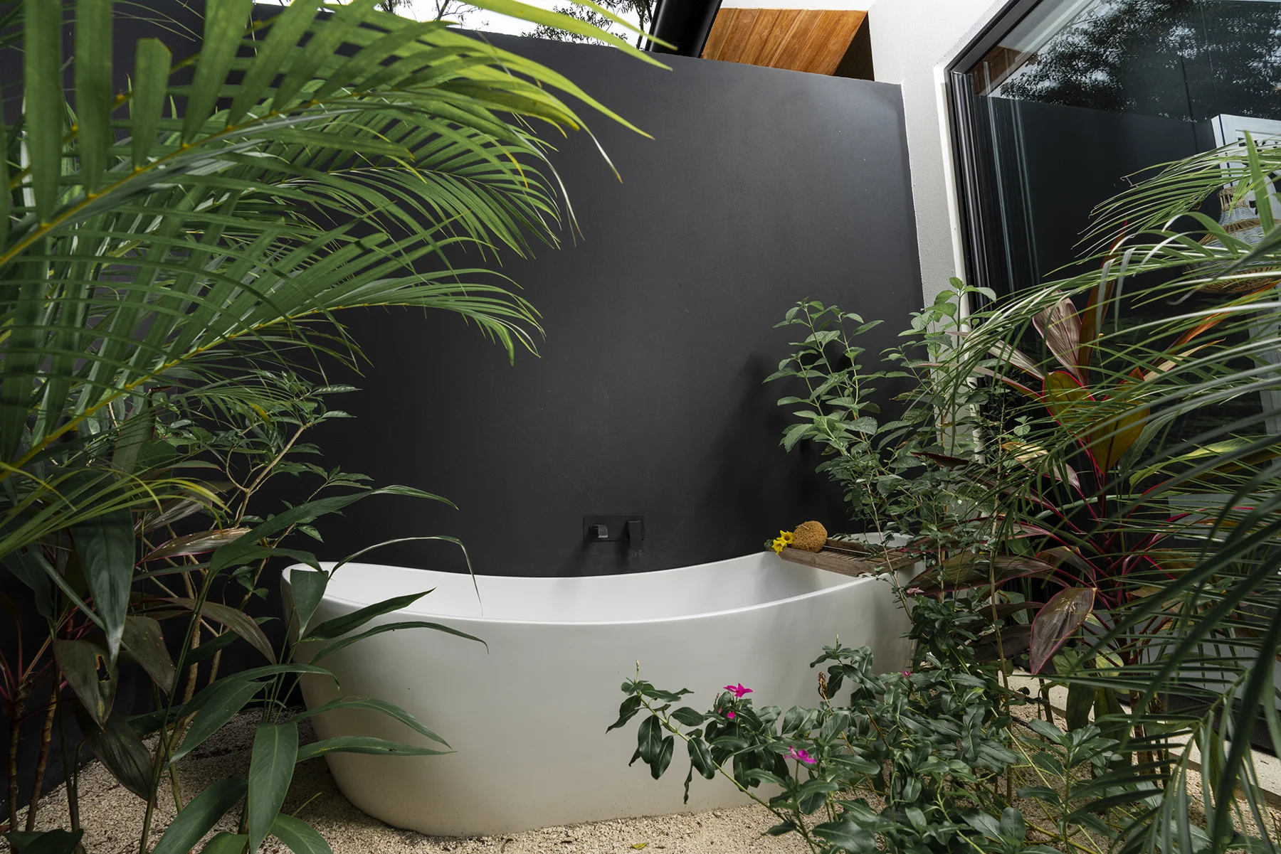 Freestanding bath surrounded by tropical planting at RG69