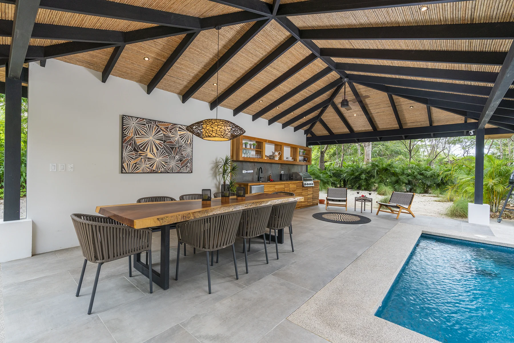 RG69 outdoor dining pavilion with a timber ceiling, tropical garden and pool